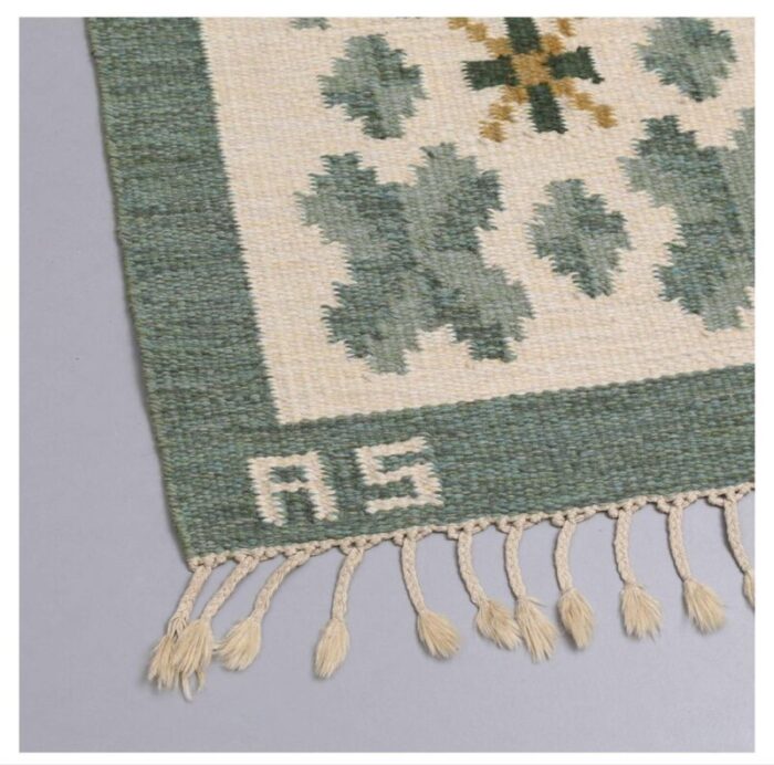 swedish flat weave rug in soft green tones on cream background 2